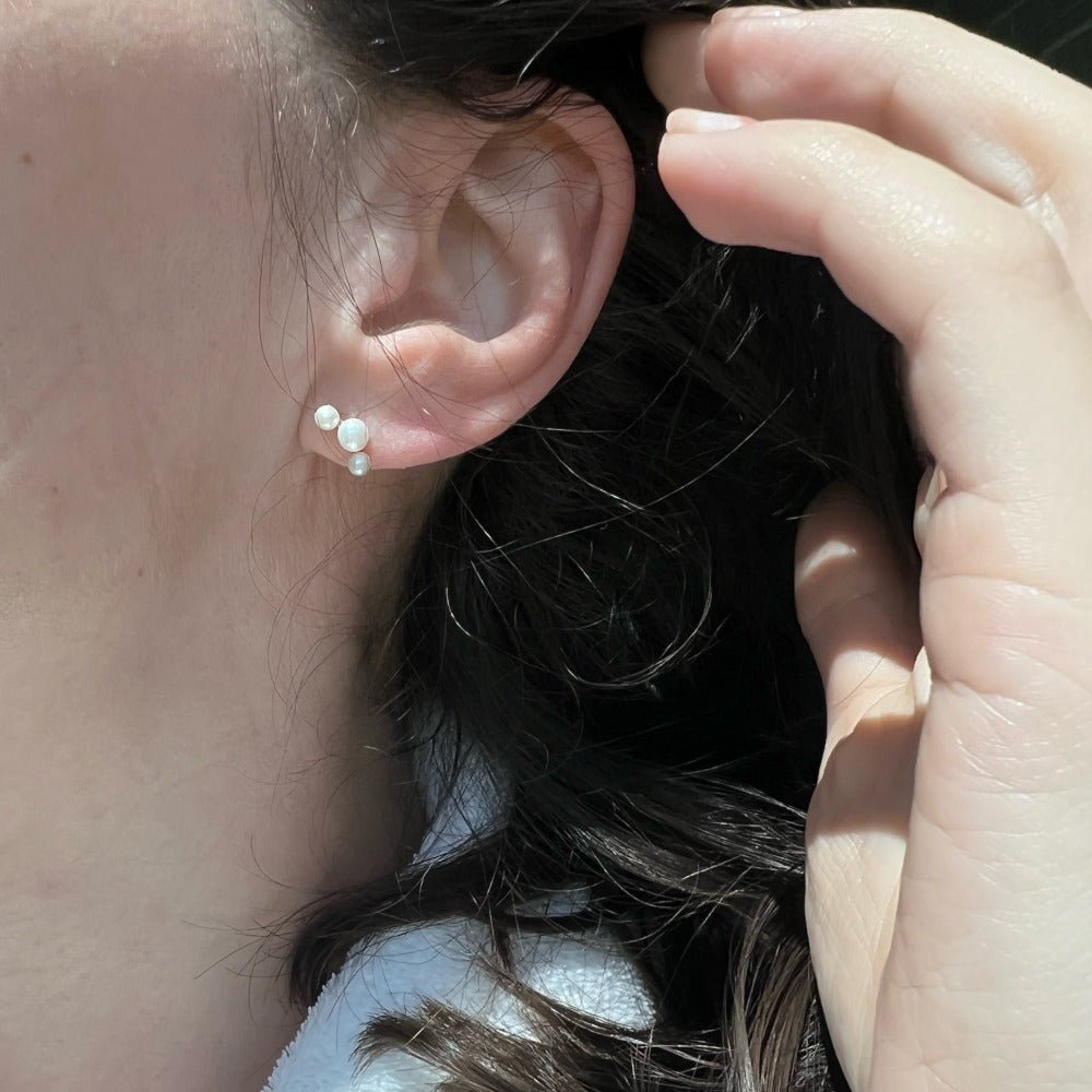 Six lustrous freshwater cultured pearls set in 14k gold. The largest pearl is 4mm and is hugged by two 3mm pearls. Earring posts have two friction groves to provide extra security and durability to hold the earring backs in place.