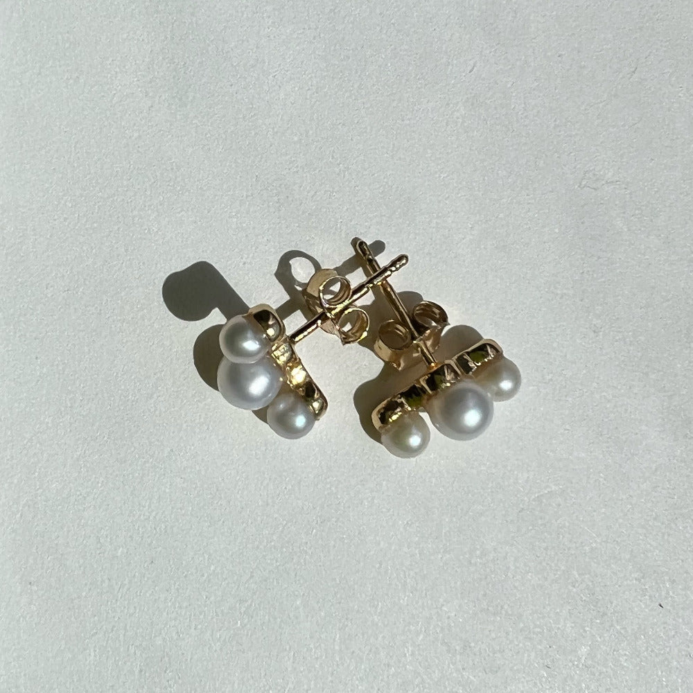 Six lustrous freshwater cultured pearls set in 14k gold. The largest pearl is 4mm and is hugged by two 3mm pearls. Earring posts have two friction groves to provide extra security and durability to hold the earring backs in place.