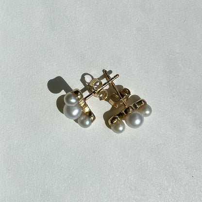 Six lustrous freshwater cultured pearls set in 14k gold. The largest pearl is 4mm and is hugged by two 3mm pearls. Earring posts have two friction groves to provide extra security and durability to hold the earring backs in place.
